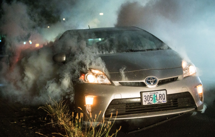 Police munitions light a neighbors Prius on fire.