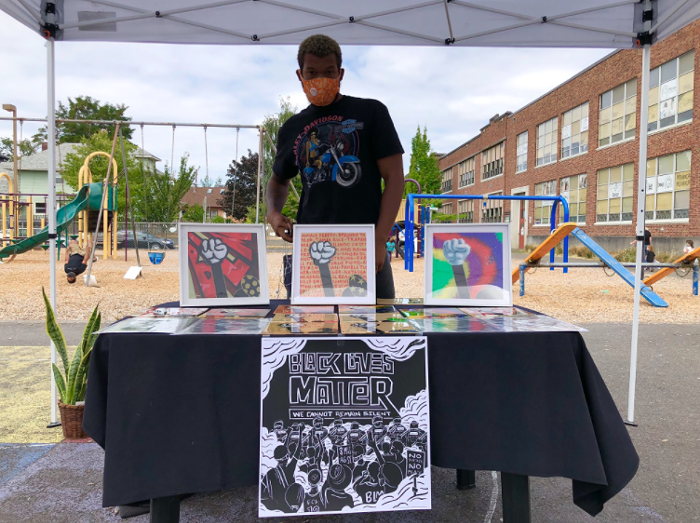 Artist Idris Jah’Son displays his work at the Black Lives Matter rally at Dr. King Elementary School.