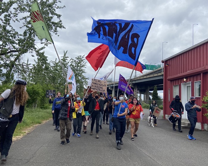 March leaders wave banners as the rally moves towards the Tilikum Bridge.