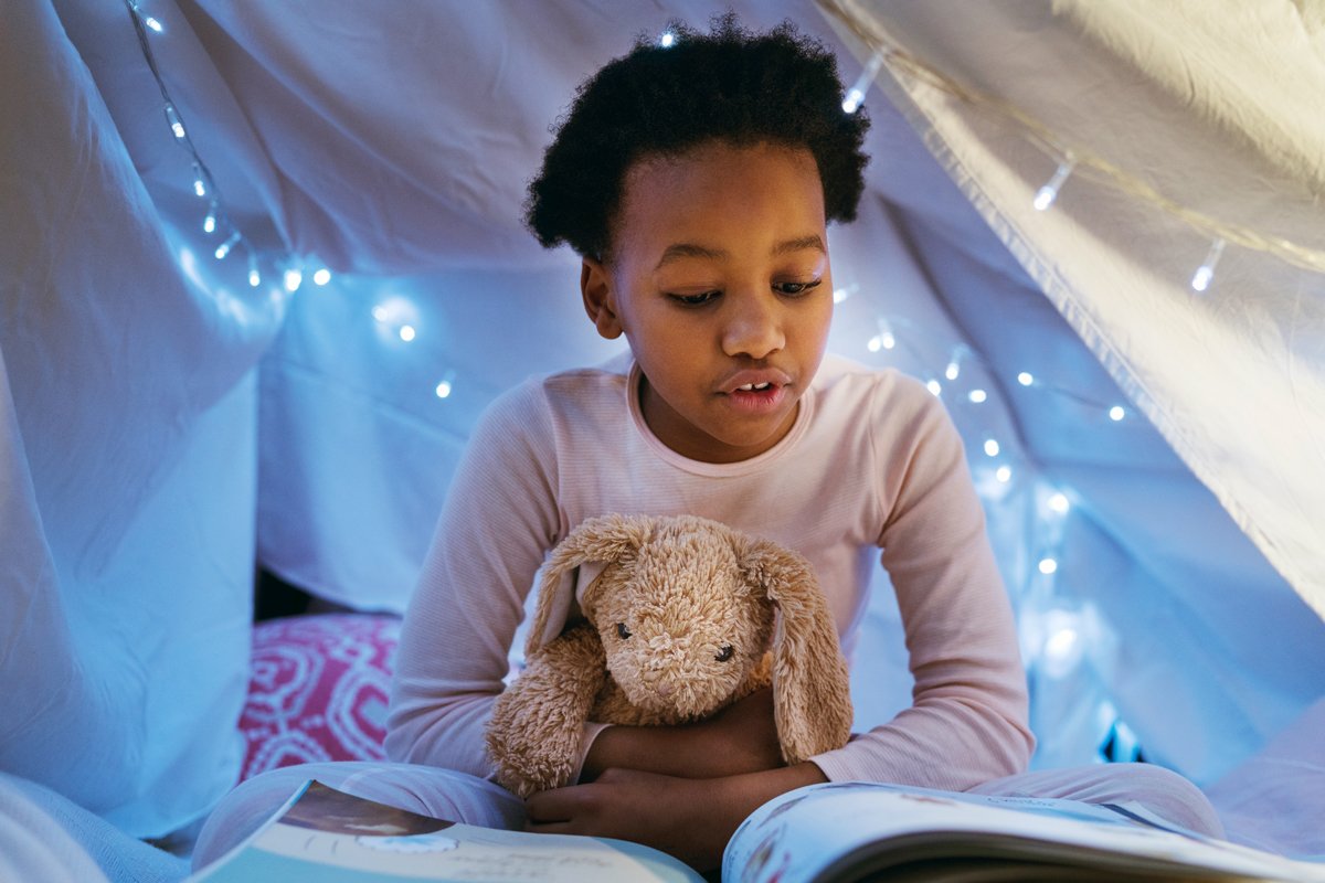 A little girl reads a book.