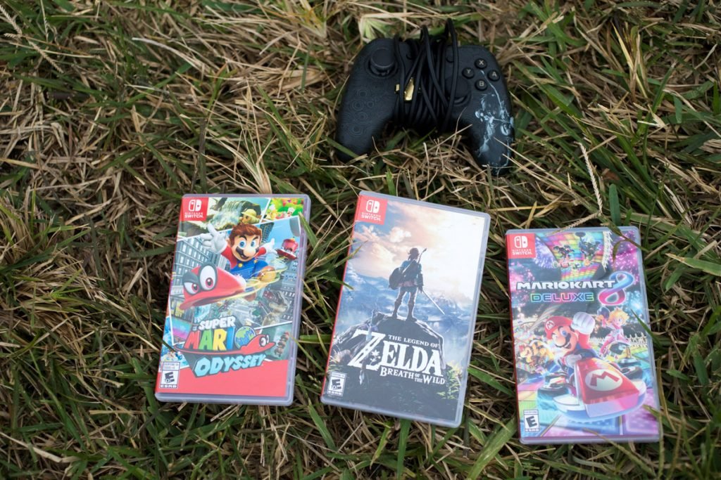 Video games lay on the grass.