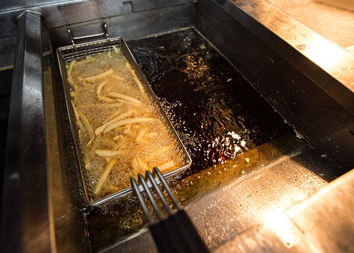 a basket of french fries frying in oil