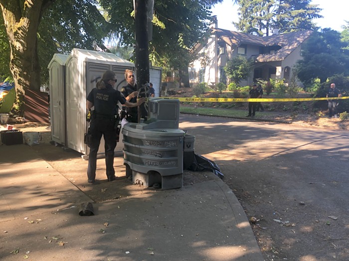 Officers with PPB close off a section of SE 37th Ave. to allow cleaning crews to work undisturbed.