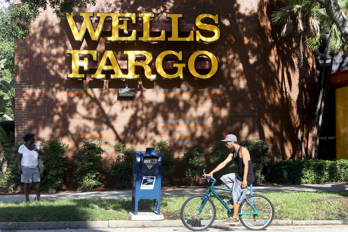 A man rides a bike past Wells Fargo in St. Petersburg, Fla.