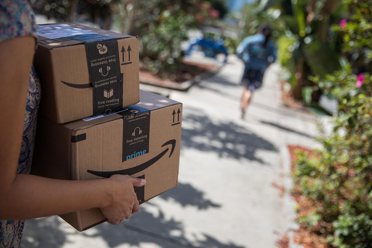 A person carries Amazon boxes to deliver