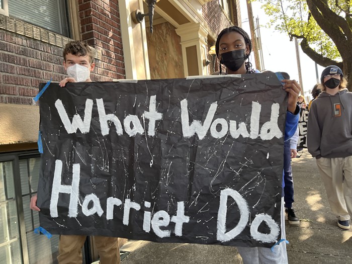 Two students holding up a poster reading What would Harriet do?